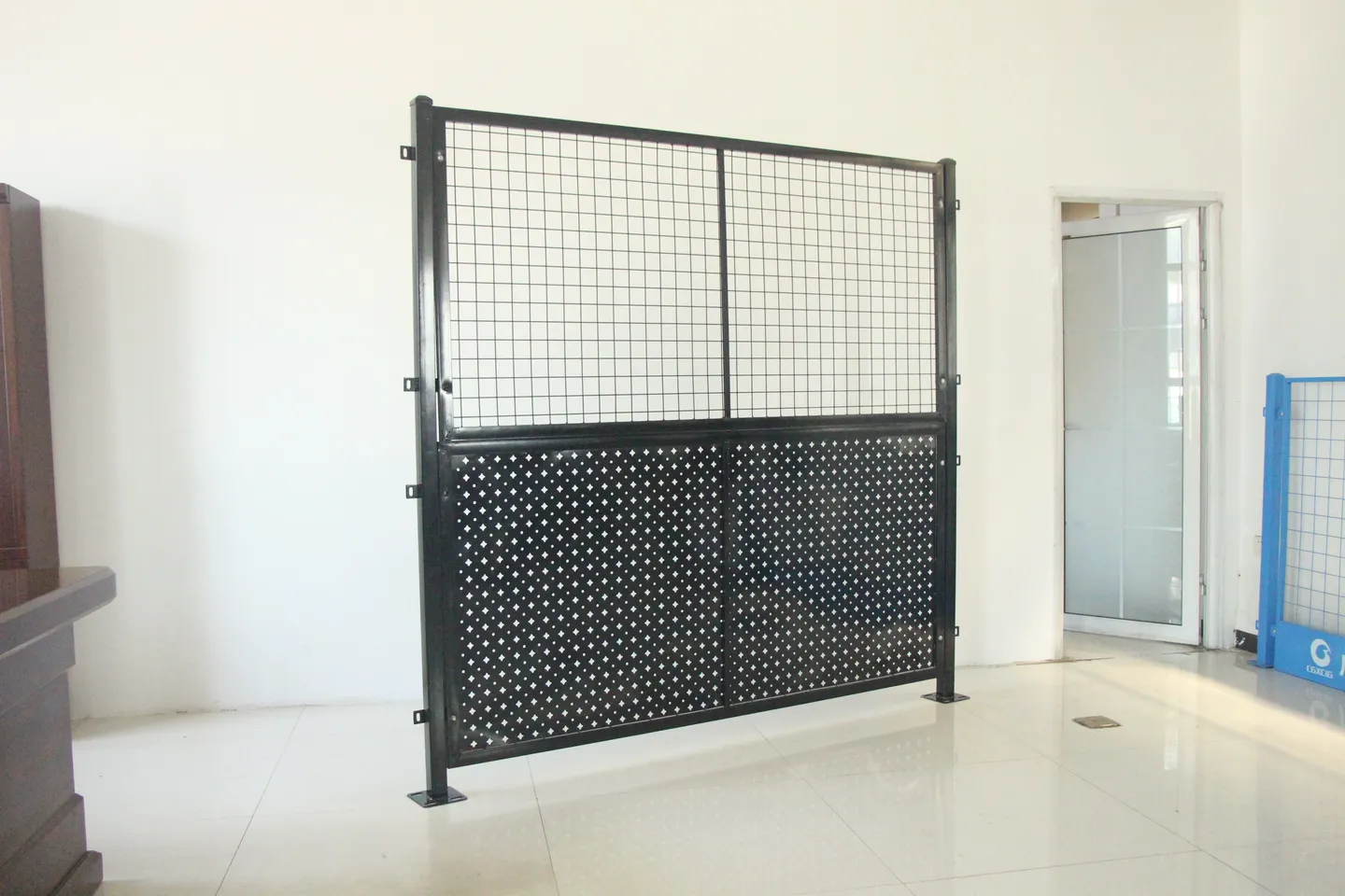 Black framed perforated metal partition with mesh upper panel