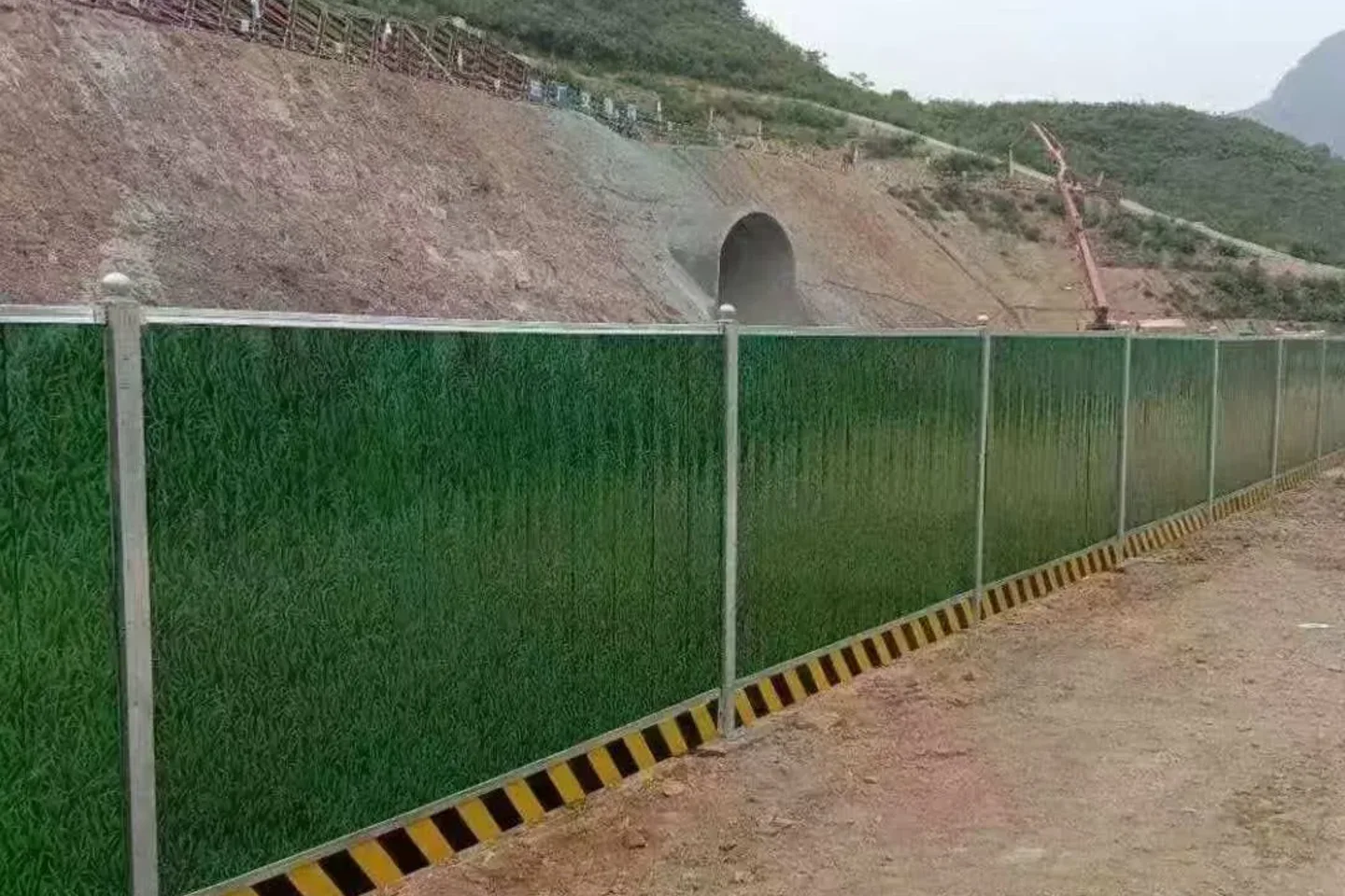 Green hoarding along a sloped works boundary