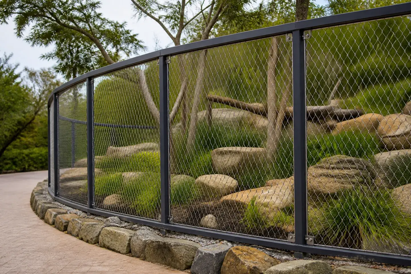 Stainless steel rope mesh held in dark frames beside a planted habitat